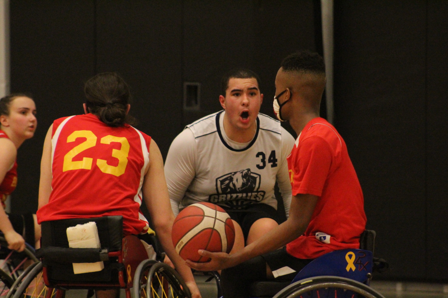 One of the youth wheelchair basketball players defending the ball from the other team