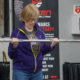Mary is lifting a weighted bar during the 8035 Adaptive Fitness program.